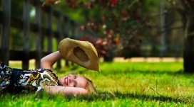 躺在绿色草坪上拿帽子的欧女