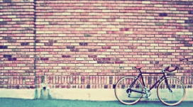 停靠在红色砖墙的自行车