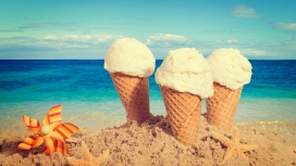 沙滩上的三个冰淇淋甜筒与风车海星