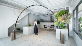 小日本花店-一个黑色金属拱加两侧弯曲的黑爬架植物是其特性，形成了照明设备和植物的支持