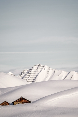 冬季白色雪山脚下的游牧居民小屋