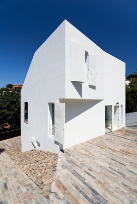 西班牙紧凑型白色立方几何形状住宅建筑-坐落在可以俯瞰巴塞罗那城市的地方，房子建在一块非常小而倾斜的松树林山谷间