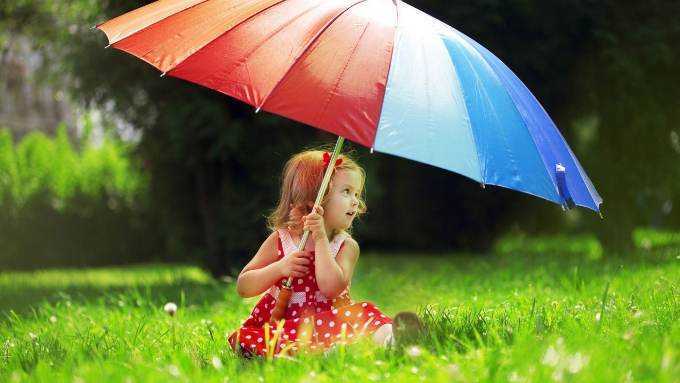小孩 图片信息简介:坐在绿色草地上手握五彩伞的国外女宝宝壁纸