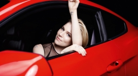 坐在红色汽车里微笑的西耶娜・米勒