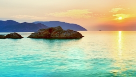 太阳下的蔚蓝海洋岩石岛屿