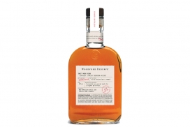 Woodford Reserve丰富水果草药口味的威士忌烈酒-一个软木塞密封的透明玻璃奶瓶，这些标签都镶有扇形边缘，并印有序列号，彰显高贵