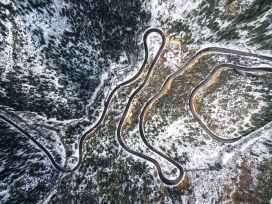高空俯拍的冬季山林蜿蜒公路