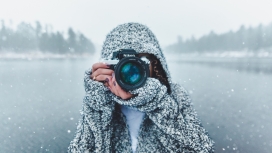 雪中拿尼康单反相机拍照的女孩