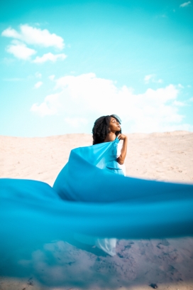 沙漠中身披蓝色绸缎的非洲姑娘