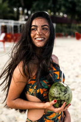 沙滩手拿椰子的黑长发姑娘