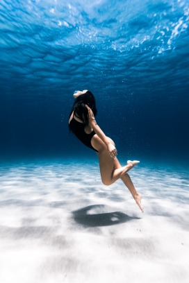 蓝色海域中潜水游泳的女子