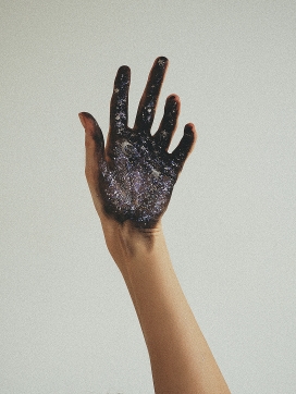 手掌贴满了黑色荧光粉的手