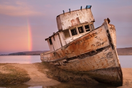 河床边遗弃废船上的彩虹