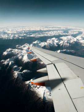 飞行在雪山上空的航班机翼