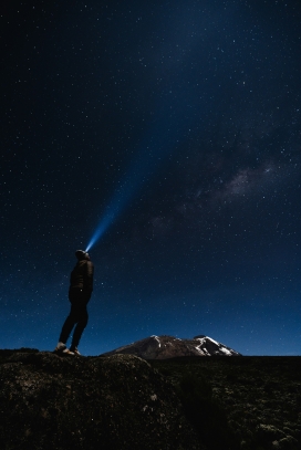 头戴手电筒看望星空夜空的行者