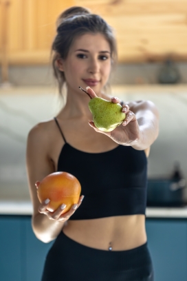 手持鲜果的健康健身女郎生活展示