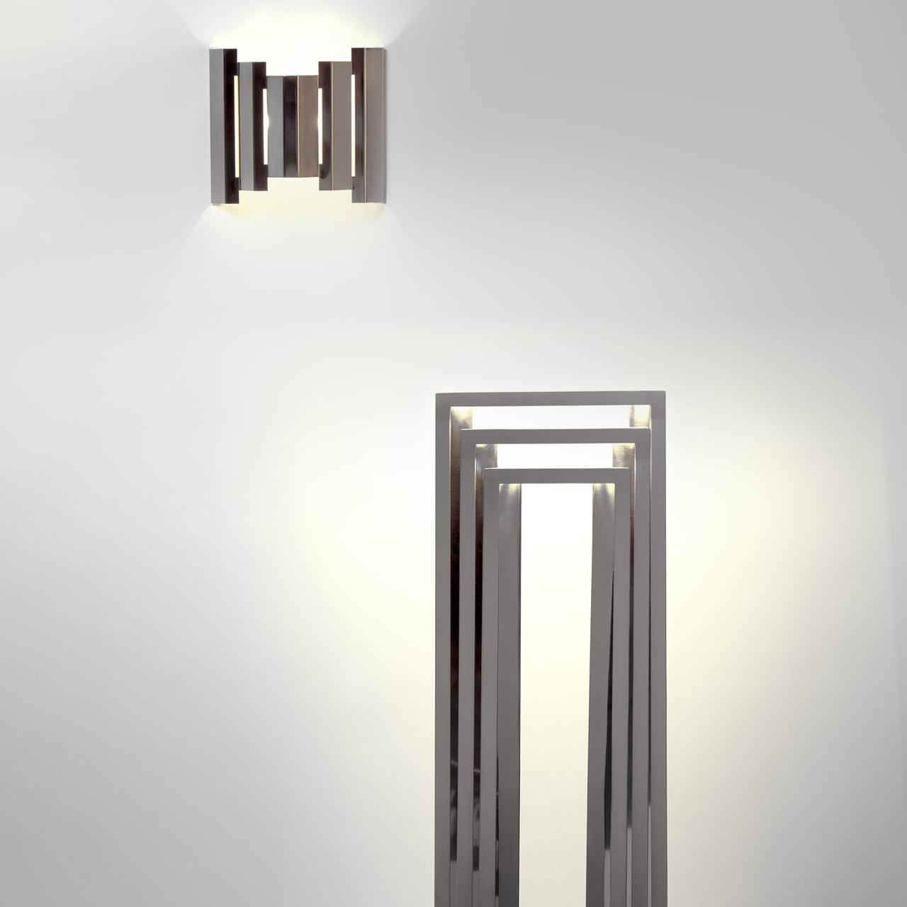 首先映入眼帘的是一个小的框架,一组重复的立柱和横杆,看起来像是凉棚的一部分。只有当你走近时,座位才会显现出来,它是由横梁交叉而成的,椅背则以同样的节奏向上延伸。它显然具有功能性,但坐在里面也像是置身于一幅画作之中,被线条以及它们投射在你身后地板和墙壁上的阴影所环绕。