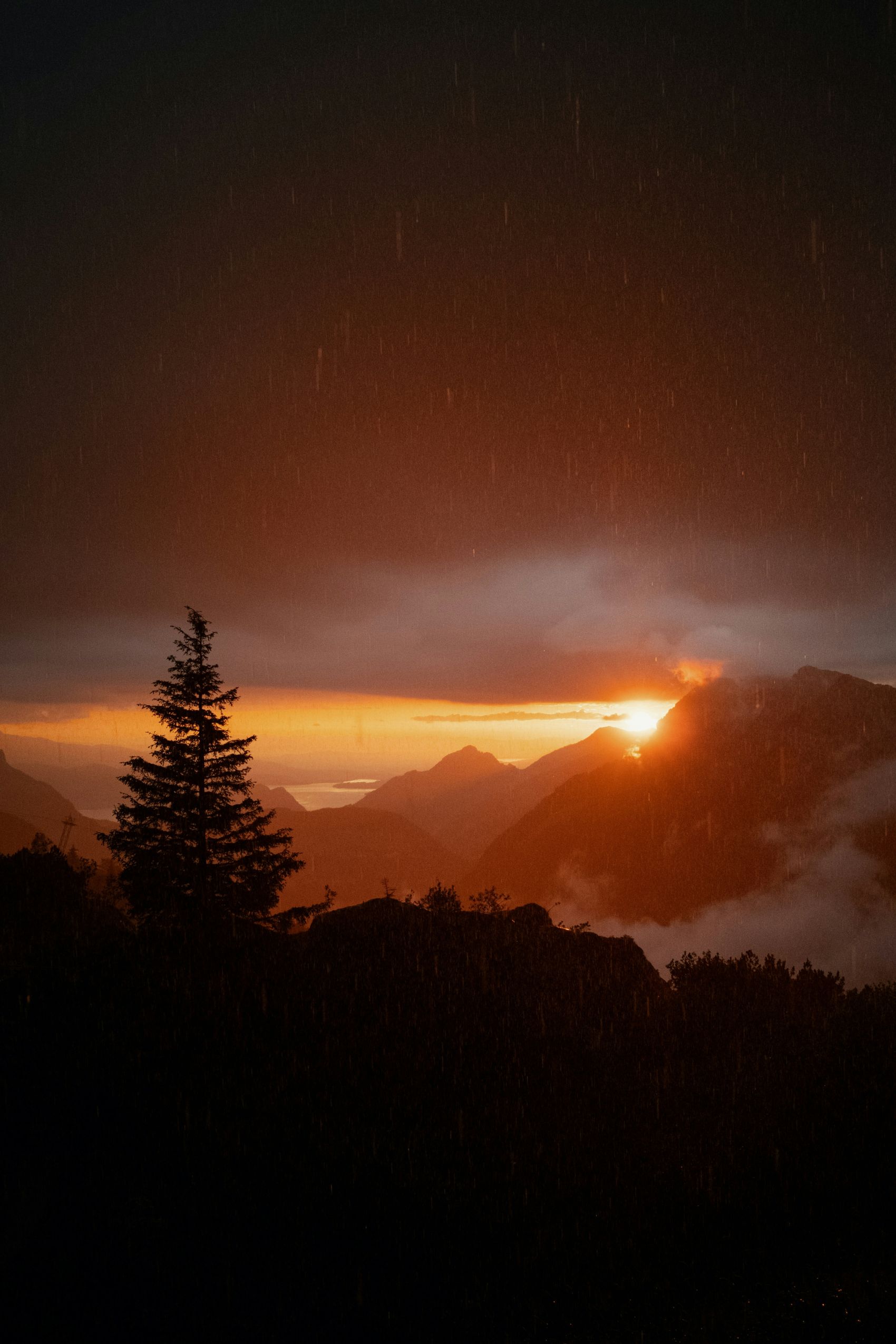 雨幕中山峰落日熔金 冷暖光影交织山野治愈氛围感图片