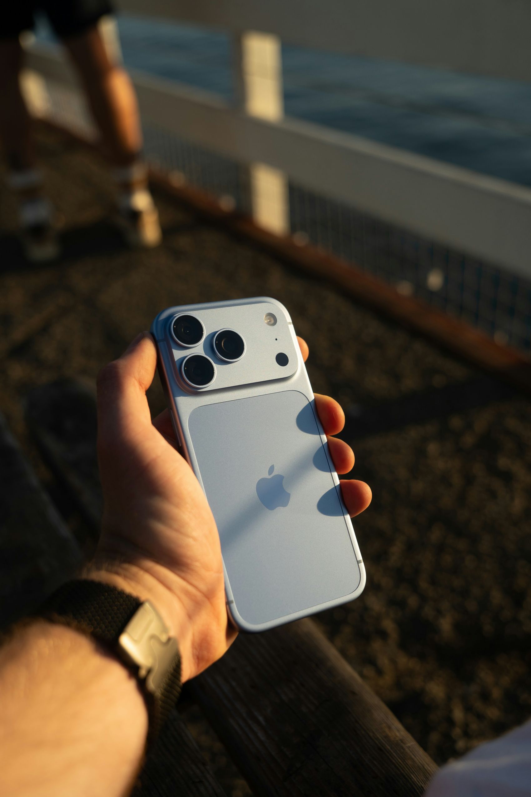 黄昏海边手持苹果 iPhone18 手机背面特写实拍图片
