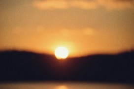 暖调日落景观：光晕笼罩的山际落日自然摄影